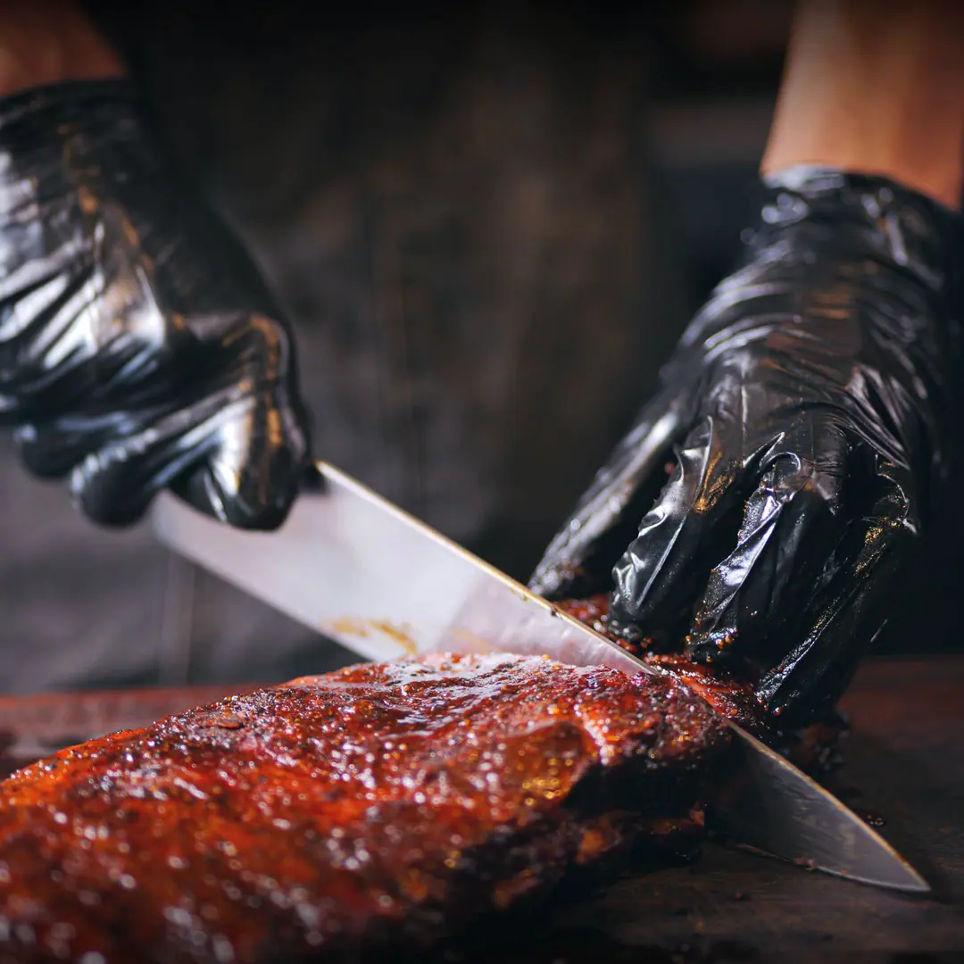 Costillar glaseado de Mr. Smoky recién cortado sobre la tabla
